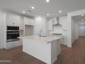 Bright, open kitchen featuring sleek white cabinetry and stainless steel appliances at 24192 W Agora Ln, Buckeye, AZ 85326