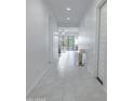 Bright hallway with neutral tile flooring leading to the outdoor patio at 24478 N 166Th Ave, Surprise, AZ 85387