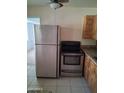 Bright kitchen with stainless steel appliances, granite countertops, and tile flooring at 2549 W Rose Ln # A223, Phoenix, AZ 85017