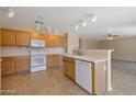 Well-lit kitchen with wooden cabinets, white appliances, and an open layout to the living area at 3023 W Quail Ave, Phoenix, AZ 85027