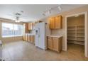 Bright kitchen featuring wooden cabinets, a large refrigerator, and a convenient walk-in pantry at 3023 W Quail Ave, Phoenix, AZ 85027