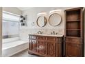 Elegant bathroom with a double vanity, granite counters, decorative mirrors, and a tiled shower at 3311 W Baylor Ln, Chandler, AZ 85226