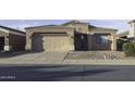 A single-story stucco home with a two-car garage and desert landscaping in the front yard at 3864 W Fairway Dr, Eloy, AZ 85131