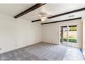 Bright and airy bedroom with exposed beam ceiling and sliding glass doors to the backyard at 4312 W Paradise Dr, Glendale, AZ 85304