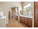 Spacious bathroom with double sinks, large mirrors, tile flooring, and a sliding door closet at 44025 N 44Th Ln, New River, AZ 85087