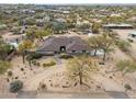 Expansive aerial view of the single-story home featuring desert landscaping and mature trees, and a pool in the backyard at 5911 E Peak View E Rd, Cave Creek, AZ 85331