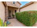 Inviting front entrance with a decorative security door, stone accents, and mature landscaping at 5948 W Leiber Pl, Glendale, AZ 85310