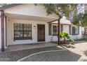 Inviting front porch with decorative door, updated windows, and xeriscaped yard at 6427 E Grandview Dr, Scottsdale, AZ 85254