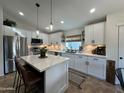 Bright kitchen with white cabinets, an island with counter seating, and modern stainless steel appliances at 853 E Ross Ave, Phoenix, AZ 85024