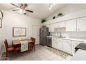 Open kitchen area with a stainless steel refrigerator and sink, white cabinets, and a wood dining table at 870 S Palm Ln # 55, Chandler, AZ 85225