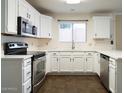 Well-lit kitchen features stainless steel appliances, white cabinets, countertops, and sleek hardware at 909 W San Mateo Ct, Gilbert, AZ 85233