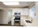 A well-lit kitchen featuring stainless steel appliances, white cabinets, countertops, and sleek hardware at 909 W San Mateo Ct, Gilbert, AZ 85233