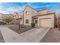 Beige two-story townhome featuring a front-facing garage, driveway, and low-maintenance landscaping at 1018 W Libra Dr, Tempe, AZ 85283