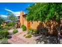 Beautiful home with desert landscaping and a custom wooden door under a bright blue sky at 10597 E Rising Sun Dr, Scottsdale, AZ 85262