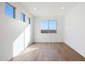 Bright bedroom featuring hardwood flooring and large windows at 14787 W El Cortez Pl, Surprise, AZ 85387