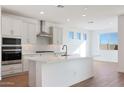 Bright kitchen with stainless steel hood and white cabinets at 14787 W El Cortez Pl, Surprise, AZ 85387