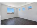 An empty bedroom featuring tiled floors, recessed lighting and three bright, sunny windows at 18447 W Mohave St, Goodyear, AZ 85338
