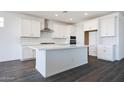 A gorgeous kitchen featuring white cabinets, a center island, stainless steel appliances and a white backsplash at 18447 W Mohave St, Goodyear, AZ 85338