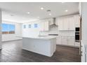 A gorgeous kitchen featuring white cabinets, a center island, stainless steel appliances and a white backsplash at 18447 W Mohave St, Goodyear, AZ 85338