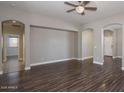 Spacious living room with hardwood floors, neutral walls, and decorative ceiling fan at 2486 E Espada Trl, Casa Grande, AZ 85194