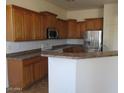 Kitchen featuring wood cabinets, tile floors, stainless steel appliances, and lots of counterspace at 32020 N 23Rd Ave, Phoenix, AZ 85085