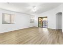 Bright and airy living room with wood-look floors, neutral walls, and sliding glass doors to the backyard at 41176 N Cambria Dr, San Tan Valley, AZ 85140