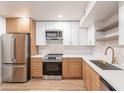 Bright kitchen features updated appliances and a combination of white and wood cabinetry at 4201 E Camelback Rd # 28, Phoenix, AZ 85018