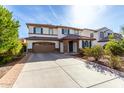 Front exterior of a two-story home with a tile roof, covered entry, and spacious driveway at 4727 S Watauga Dr, Gilbert, AZ 85297