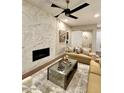 Cozy living room featuring an electric fireplace, modern furniture and a ceiling fan at 5250 E Deer Valley Dr # 246, Phoenix, AZ 85054