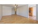 Bright living room featuring hardwood floors, white walls, and an open layout adjacent to the kitchen at 5626 S Doubloon Ct # E, Tempe, AZ 85283