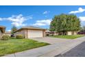 Well-maintained single-story home with an attached garage and verdant lawn at 9606 W Shasta Dr, Sun City, AZ 85351