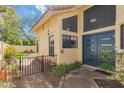Home's entrance featuring a blue modern door, brick entryway, and secure gate at 13375 N 96Th Pl, Scottsdale, AZ 85260