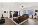 Bright living room showcasing wood tile floors, a ceiling fan, and a large window with natural light at 18059 W Tanglewood Dr, Goodyear, AZ 85338