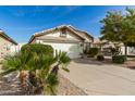 Home featuring a two-car garage with desert landscaping and trees in the front yard at 20615 N 105Th Ave, Peoria, AZ 85382