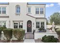 Inviting townhome exterior featuring a decorative wreath, seating area, and well-maintained bushes at 2477 W Market Pl # 18, Chandler, AZ 85248