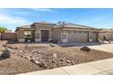 Single-story home featuring desert landscaping, a three-car garage and a covered entryway at 2561 E Toledo Ct, Gilbert, AZ 85295