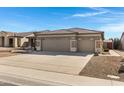 Single-story home featuring a three-car garage with desert-style landscaping and a cement driveway at 2561 E Toledo Ct, Gilbert, AZ 85295