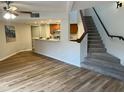 Inviting living room featuring hardwood floors and stairs leading to the next level and open kitchen at 3228 W Glendale Ave # 103, Phoenix, AZ 85051