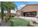 Expansive backyard offers a putting green, covered patio with seating, desert plants and unobstructed sky view at 4021 S Tumbleweed Ct, Chandler, AZ 85248