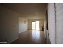 Bright living room features neutral paint, tile floor, and sliding glass doors to the outside patio at 4409 E Wood St, Phoenix, AZ 85040