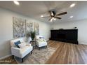 Cozy living room with hardwood floors, fireplace, and two armchairs at 4524 W Larkspur Dr, Glendale, AZ 85304