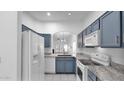 A well-maintained kitchen features stylish blue cabinets and modern appliances at 4533 N 22Nd St # 228, Phoenix, AZ 85016