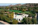 Expansive estate with a pool, set against a backdrop of golf course and mountains, offering luxury and scenic views at 4900 E Desert Fairways Dr, Paradise Valley, AZ 85253