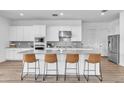 Modern kitchen boasts white cabinets, stainless steel appliances, and a large island with seating at 5611 S Feliz --, Mesa, AZ 85212