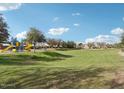 Community playground with colorful play structure and green space under a partly cloudy sky at 6113 E Artemis Dr, Florence, AZ 85132