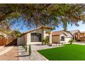Charming single-story home showcasing gravel landscaping, a red tile roof, and a well maintained lawn at 7849 W Kristal Way, Glendale, AZ 85308