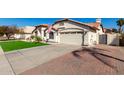 Beautiful single-story home with well-kept landscaping, an American flag, and a long, wide driveway at 7849 W Kristal Way, Glendale, AZ 85308