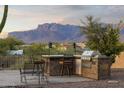 Outdoor built-in kitchen features a bar and grill, perfect for entertaining against a backdrop of mountain views at 10322 E Breathless Ave, Gold Canyon, AZ 85118