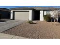 Close up view of a home's front exterior, featuring a well-maintained gravel yard and paved walkway to the entrance at 13342 W Lariat Ln, Peoria, AZ 85383