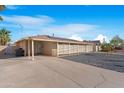 Low-angle view of a single-story home with desert landscaping, solar panels and a covered carport at 1434 N Casa Grande Ave, Casa Grande, AZ 85122